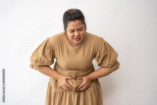 фотографія Young Asian plus size woman hand on stomach because nausea, painful disease feeling unwell,  may develop gallstones or Cholecystitis