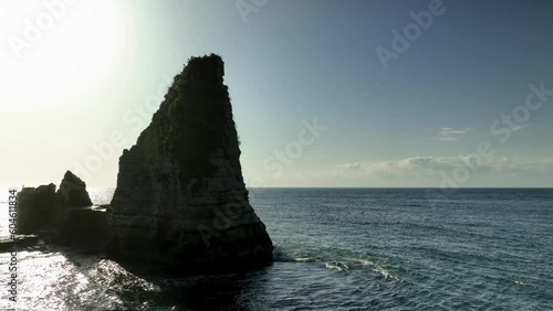 朝日に照らされる海から突き出た奇石と切り立った崖の海岸線　空撮 photo