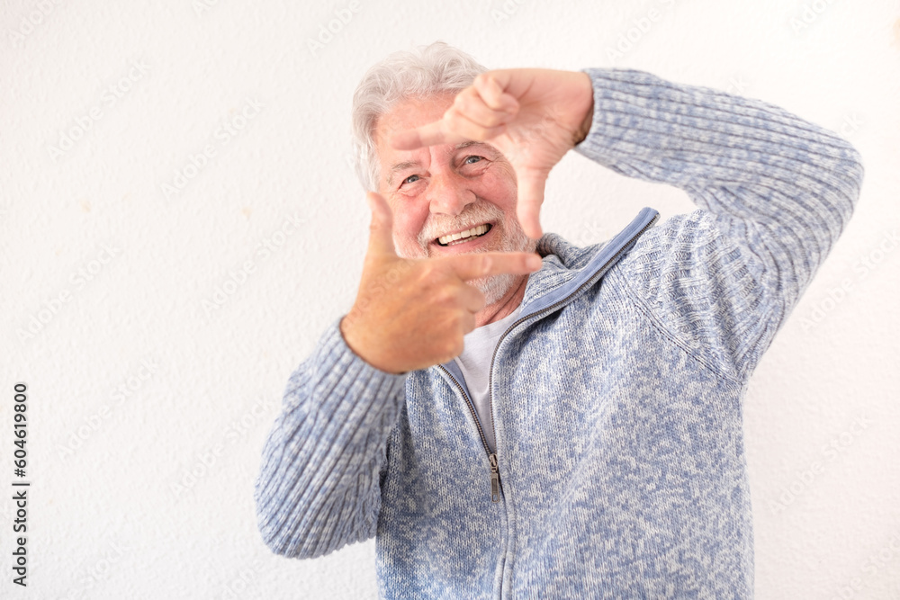Portrait of happy bearded senior man in blue casual sweater gesturing photo frame looking at camera smiling standing on white background Portrait of happy bearded senior man in blue casual sweater gesturing photo frame looking at camera smiling standing on white background
