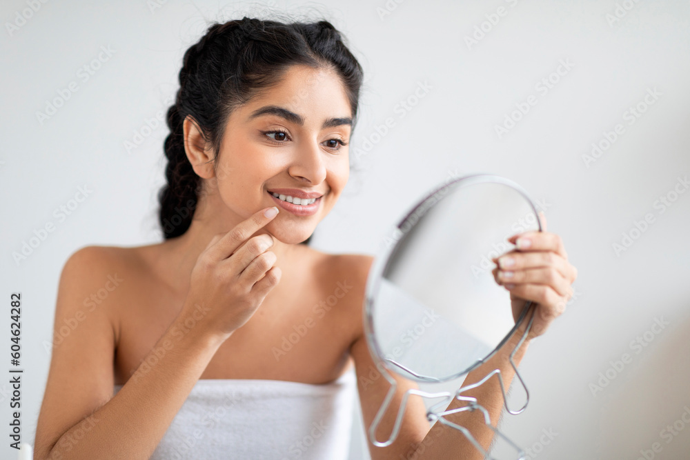 Portrait Of Smiling Indian Woman Holding Mirror And Touching Lips With Finger Portrait Of Smiling Indian Woman Holding Mirror And Touching Lips With Finger