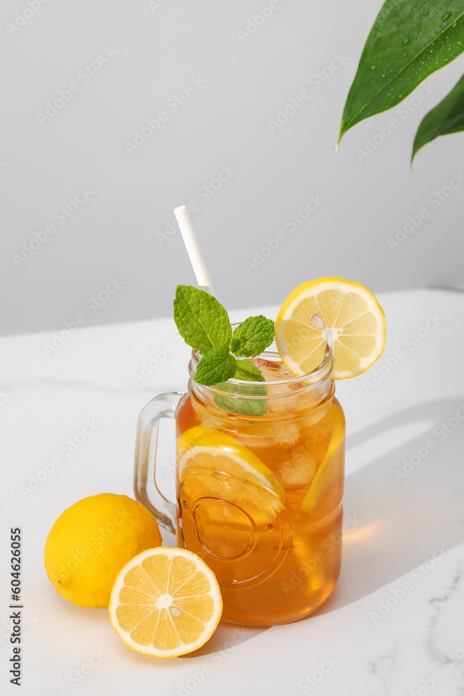 A glass of cold tea, ice cubes, lemon slices and a sprig of mint. Cooling summer drinks. A glass of cold tea, ice cubes, lemon slices and a sprig of mint. Cooling summer drinks.
