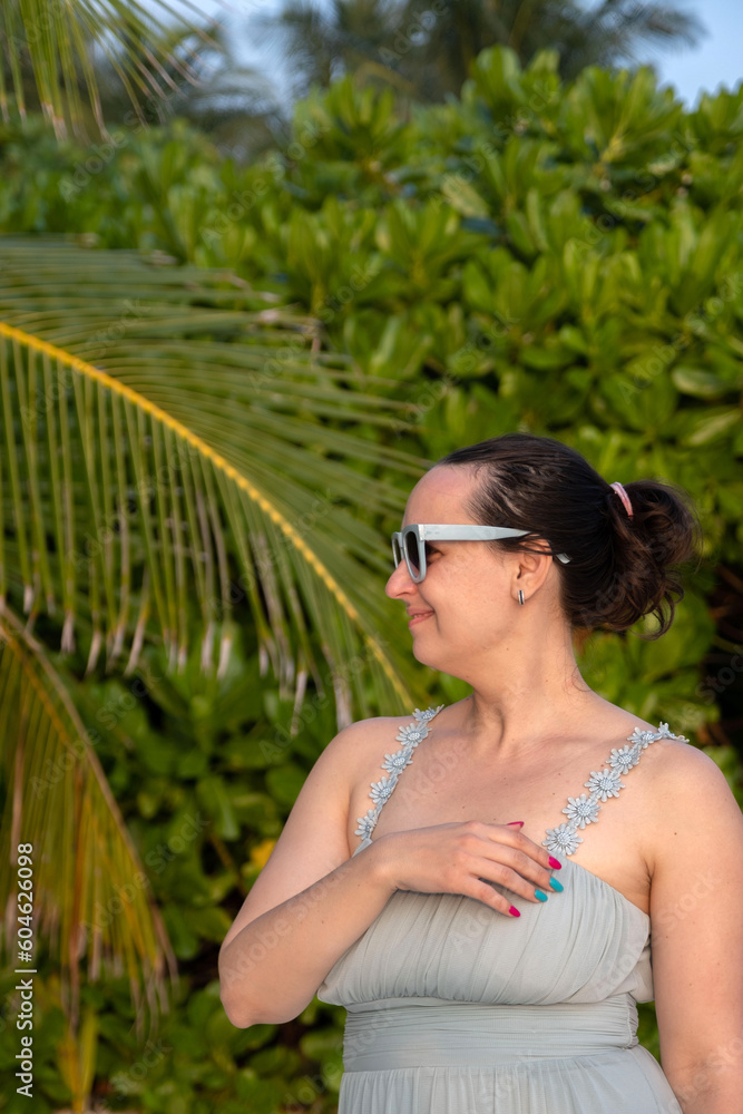 Female near richness of the beautiful green leaves on tropical beach on Maldives Female near richness of the beautiful green leaves on tropical beach on Maldives