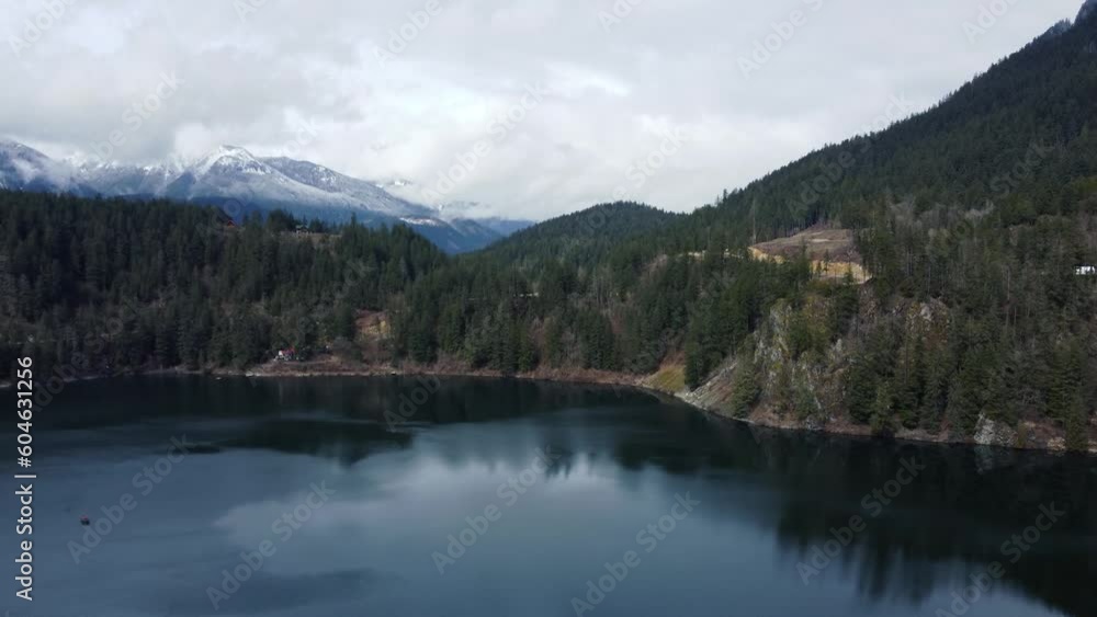 Enchanted wilderness: Drone soars above a serene lake nestled among majestic cloud-kissed mountains Enchanted wilderness: Drone soars above a serene lake nestled among majestic cloud-kissed mountains