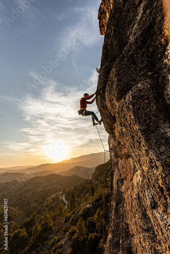 man climbing at sunset on a trip, fearless courageous person, fearless person, extreme sport confidence dramatic sky, sport professional mountain safety, risk of accidents