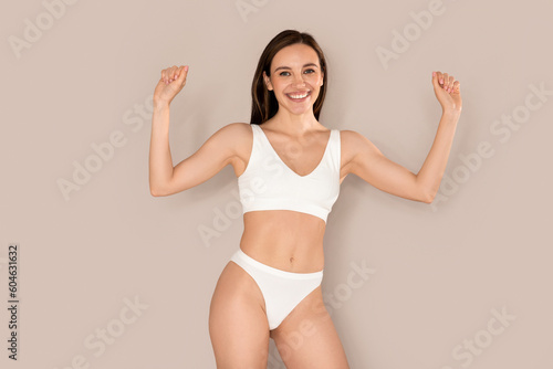 Excited happy young woman in underwear celebrating success on beige © Prostock-studio