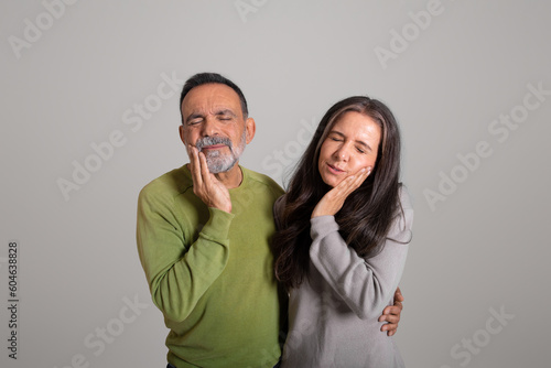 Unhappy sad european old couple take hand to cheek, suffering from toothache © Prostock-studio