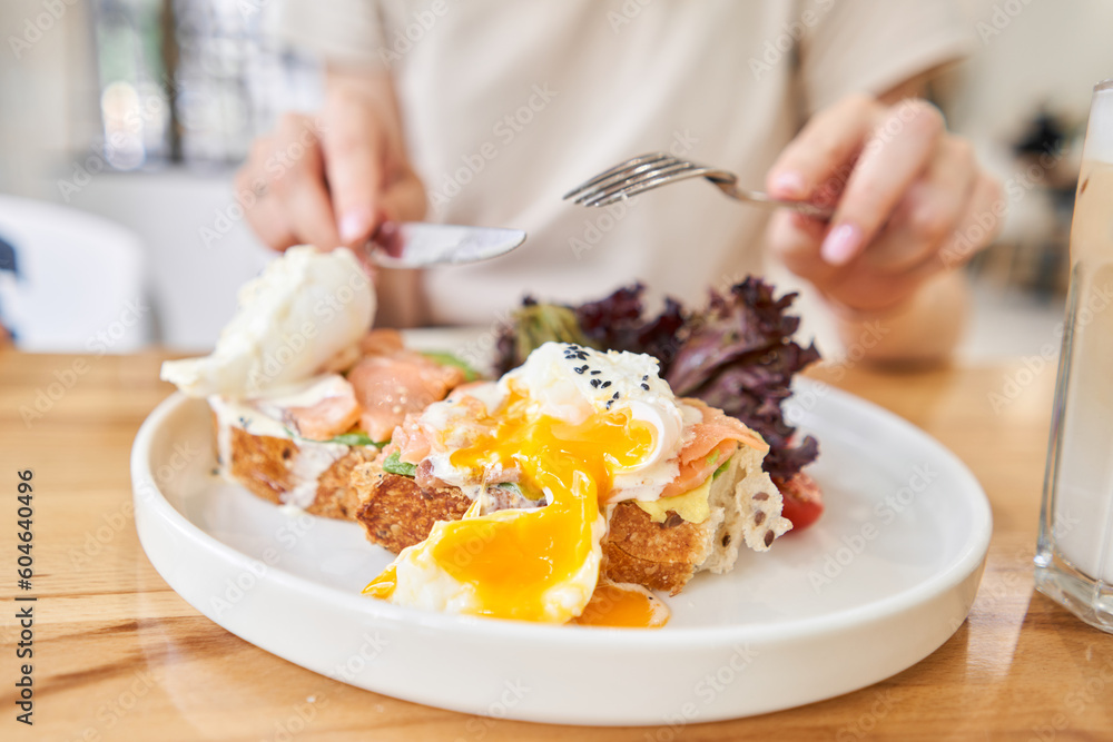 restaurant dish Brioche with poached egg with salmon and avocado. Delicious bread with greens restaurant dish Brioche with poached egg with salmon and avocado. Delicious bread with greens