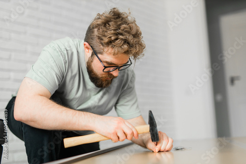 Portrait of man assembling furniture. Do it yourself furniture assembly at home