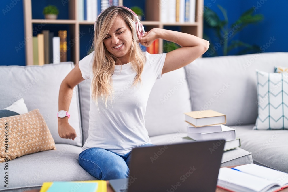 Young blonde woman studying using computer laptop at home stretching back, tired and relaxed, sleepy and yawning for early morning Young blonde woman studying using computer laptop at home stretching back, tired and relaxed, sleepy and yawning for early morning