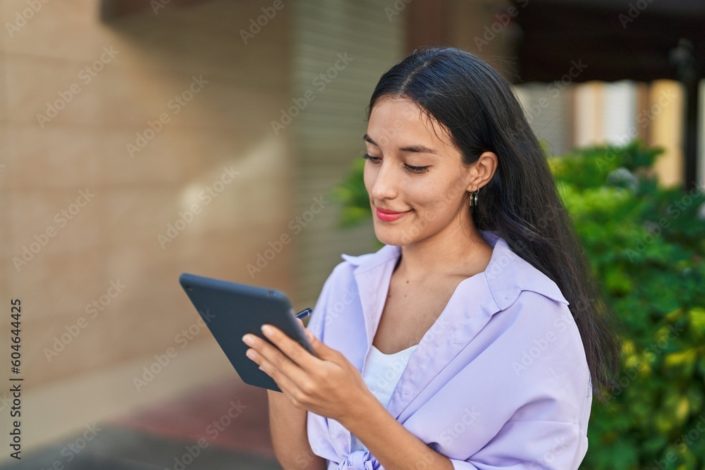 Young beautiful hispanic woman smiling confident using touchpad at street Young beautiful hispanic woman smiling confident using touchpad at street