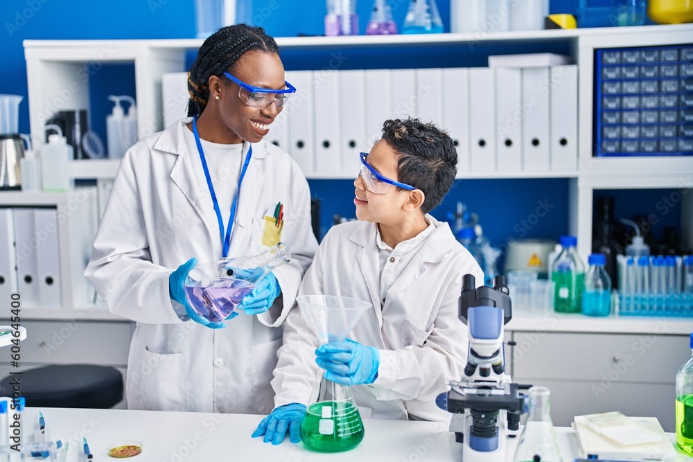 Fototapeta premium African american mother and son scientists pouring liquid laboratory