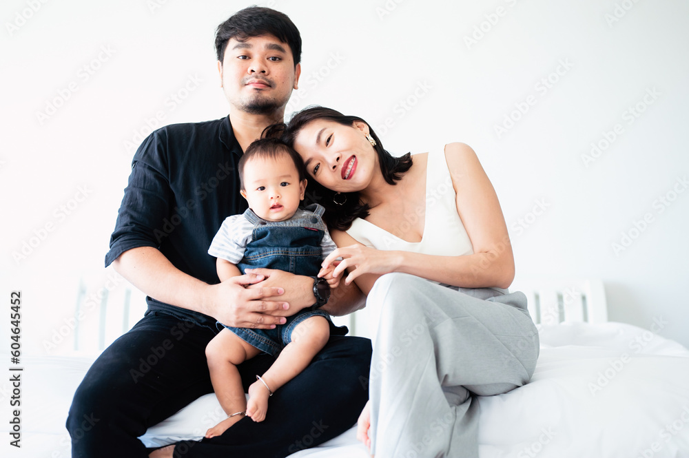 Smiling Asian family in white bedroom with dad Mother and son Smiling Asian family in white bedroom with dad Mother and son