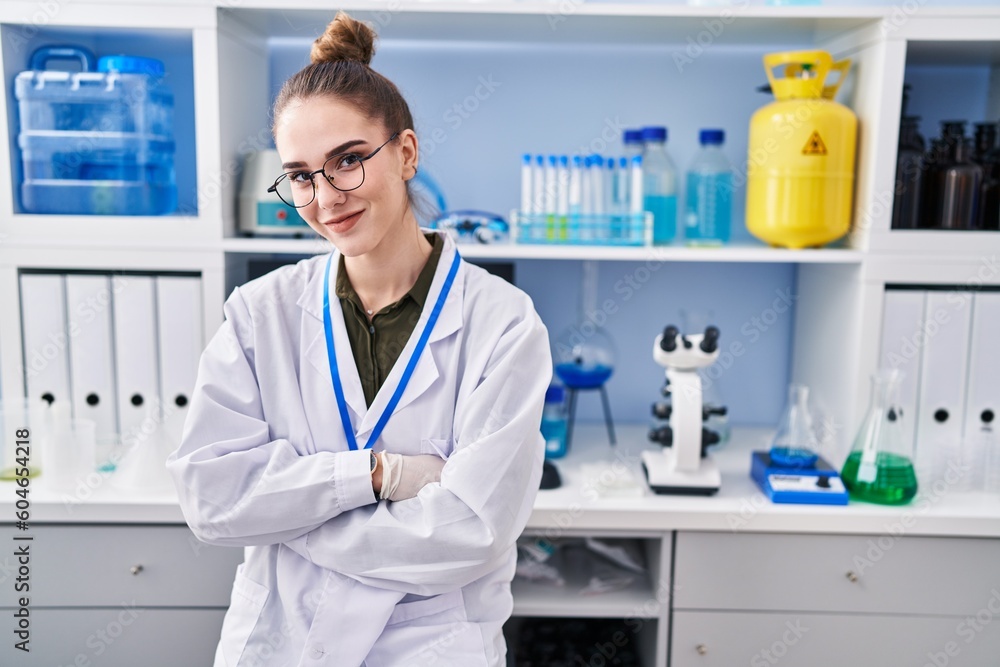 Young hispanic girl working at scientist laboratory happy face smiling with crossed arms looking at the camera. positive person. Young hispanic girl working at scientist laboratory happy face smiling with crossed arms looking at the camera. positive person.
