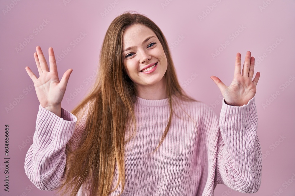 Young caucasian woman standing over pink background showing and pointing up with fingers number ten while smiling confident and happy. Young caucasian woman standing over pink background showing and pointing up with fingers number ten while smiling confident and happy.