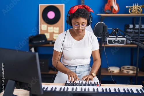 African american woman musician playing piano at music studio © Krakenimages.com