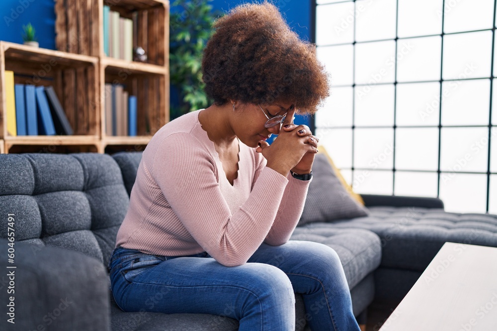 African american woman stressed sitting on sofa at home African american woman stressed sitting on sofa at home