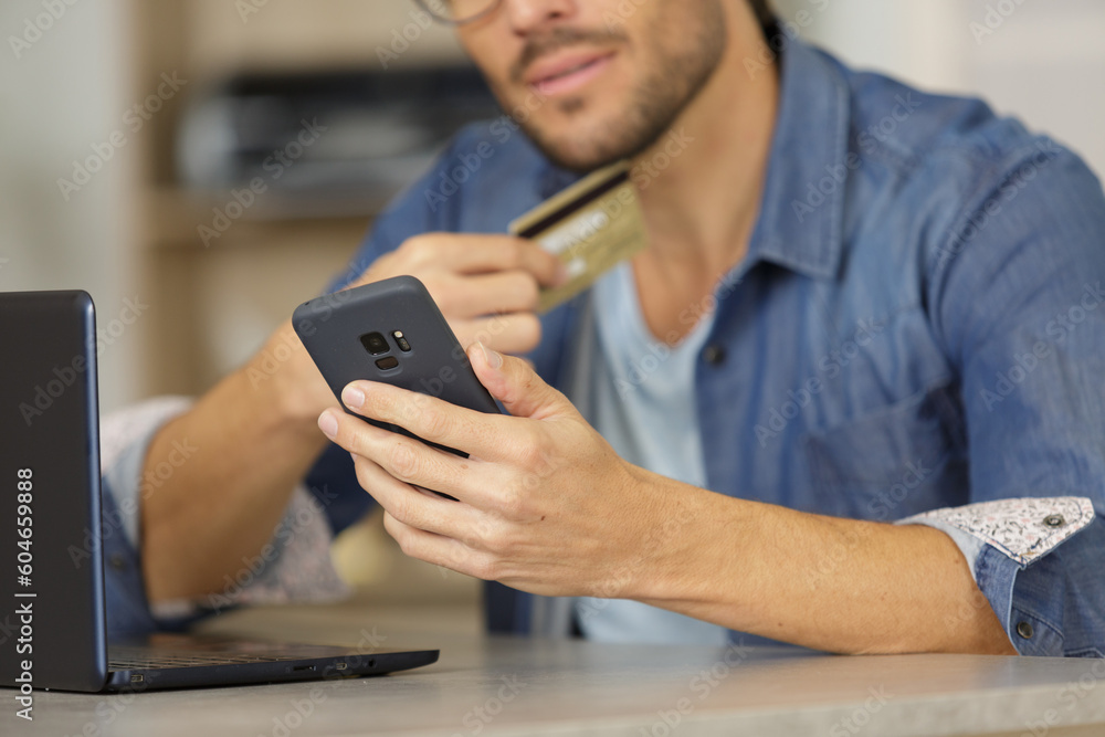 man shopping with a card with a smartphone man shopping with a card with a smartphone