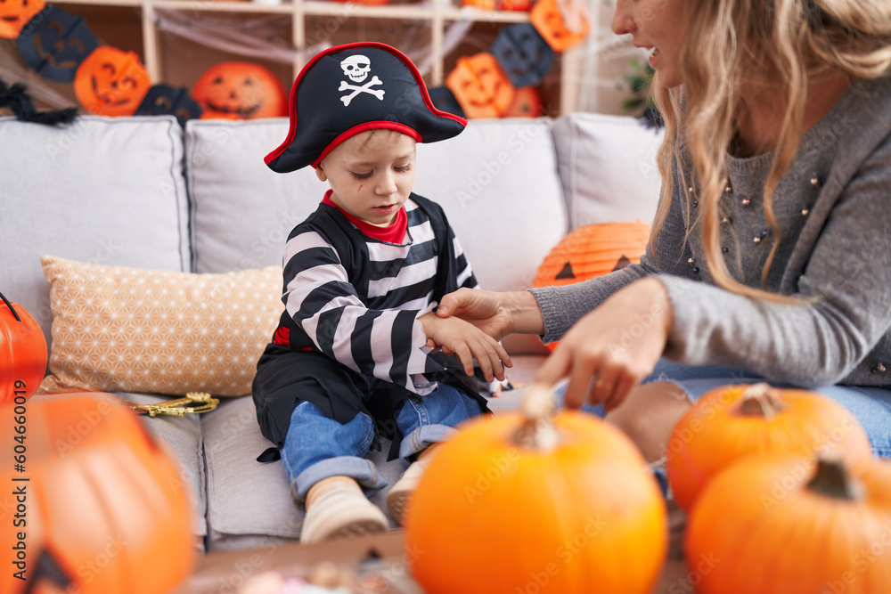 Adorable caucasian boy wearing pirate costume having draw on hand at home Adorable caucasian boy wearing pirate costume having draw on hand at home