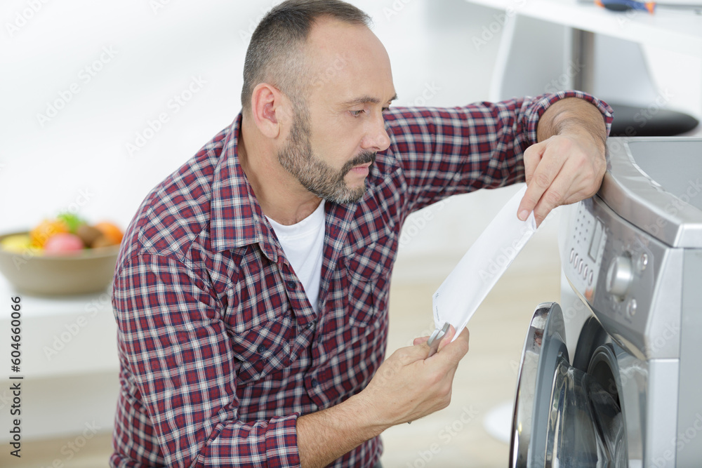 man reading washing machine instructions man reading washing machine instructions