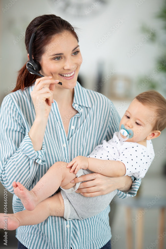 busy businesswoman working with baby on lap busy businesswoman working with baby on lap