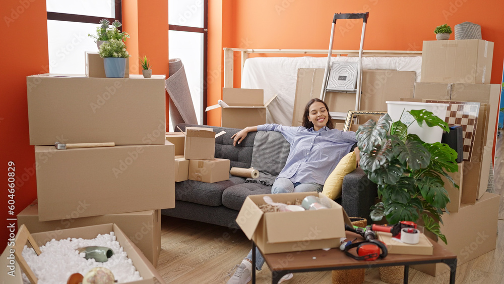 Young beautiful hispanic woman smiling proud sitting on sofa at new home Young beautiful hispanic woman smiling proud sitting on sofa at new home