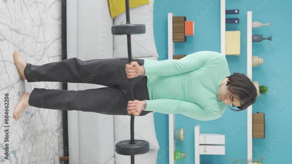 vertical-video-of-funny-looking-sportsman-hurting-his-arm-while-lifting