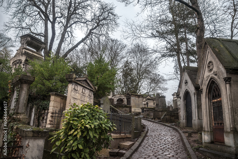 PARIS, FRANCE - DECEMBER 22, 2017: Graves from the 19th century in Pere Lachaise Cemetery in Paris, France, during a cold cloudy winter afternoon. Pere Lachaise Cemetery is the largest cemetery in Par