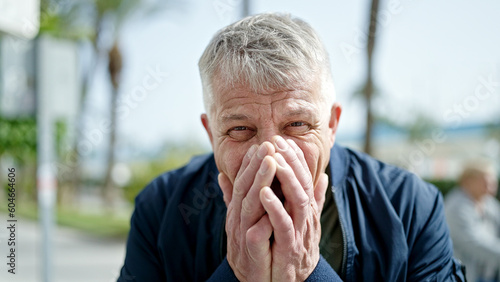 Middle age grey-haired man laughing a lot at park