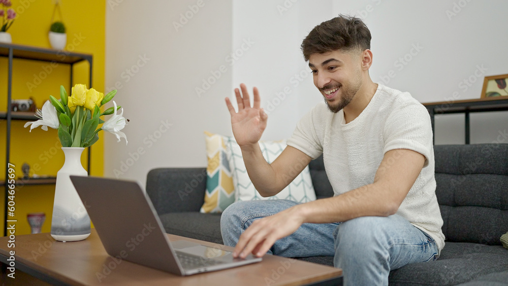 Young arab man having video call sitting on sofa at home Young arab man having video call sitting on sofa at home
