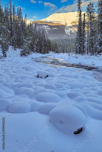 Rocks covered in snow beside frozen creek