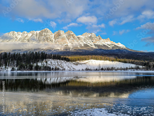 Sunshine on reflecting river near snowy mountains