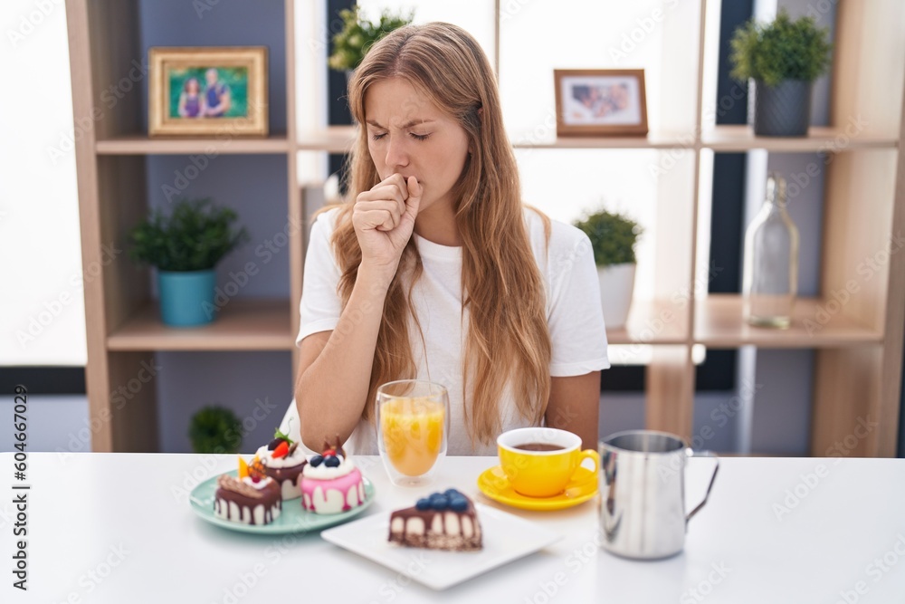 Young caucasian woman eating pastries t for breakfast feeling unwell and coughing as symptom for cold or bronchitis. health care concept.