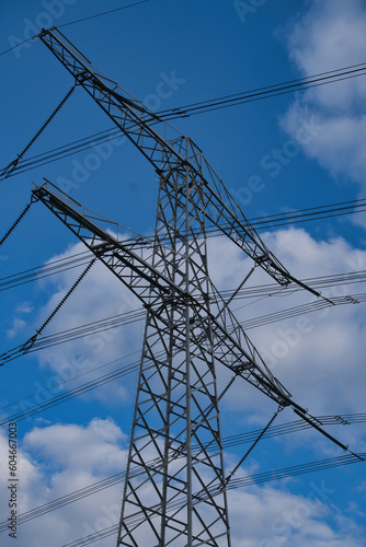 photo of an electricity pylon in the netherlands with blue skies with a single cloud