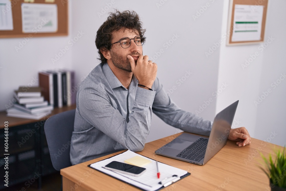 Young hispanic man business worker using laptop with doubt expression at office Young hispanic man business worker using laptop with doubt expression at office