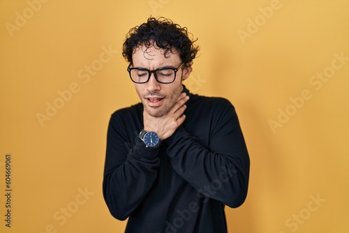 Hispanic man standing over yellow background shouting suffocate because painful strangle. health problem. asphyxiate and suicide concept. © Krakenimages.com