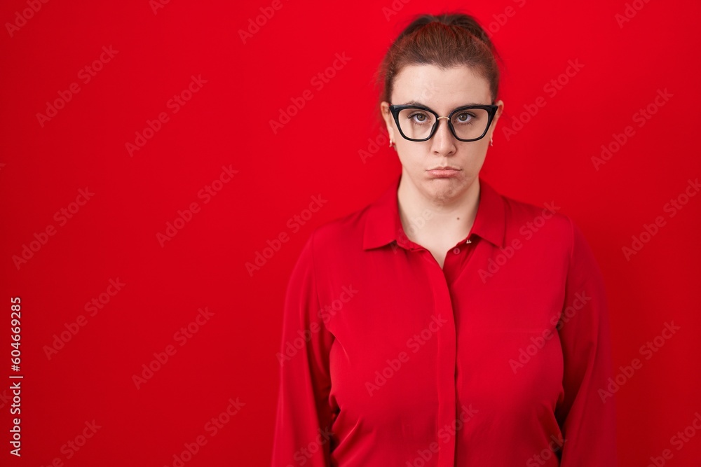 Young hispanic woman with red hair standing over red background depressed and worry for distress, crying angry and afraid. sad expression. Young hispanic woman with red hair standing over red background depressed and worry for distress, crying angry and afraid. sad expression.