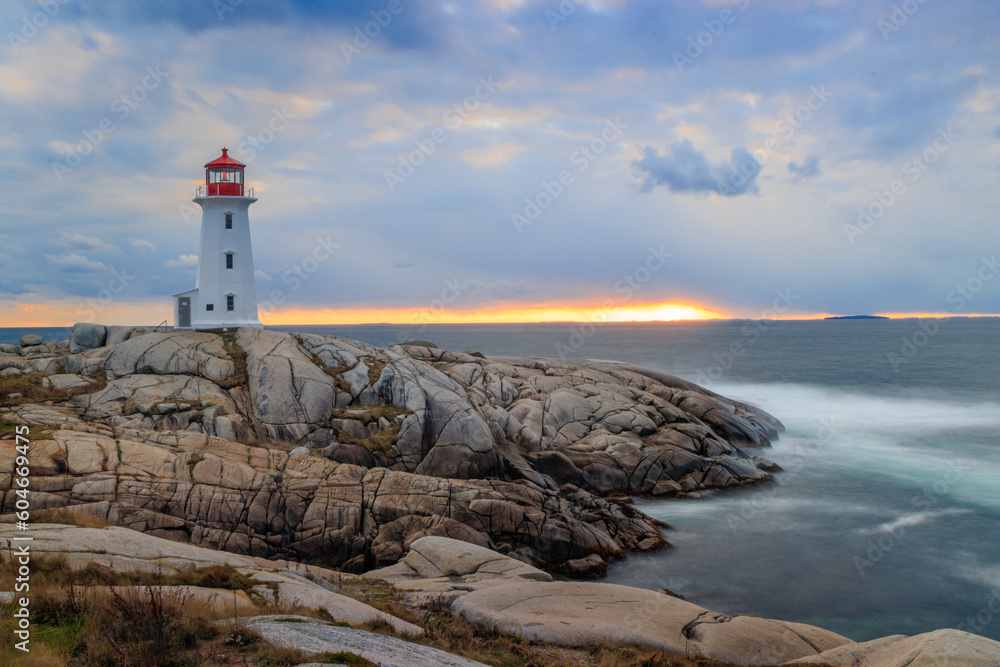 Lighthouse with smooth water beside rocks