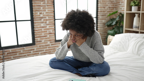 African american woman lying on bed with boring expression at bedroom