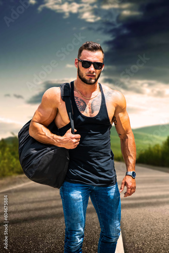 Muscular attractive athletic man in city park