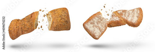 Two loaves of crispy bread isolated on white. Loaves of freshly baked crispy bread are broken in half with crumbs flying in all directions at the break. Top and bottom view. Fresh baking concept.
