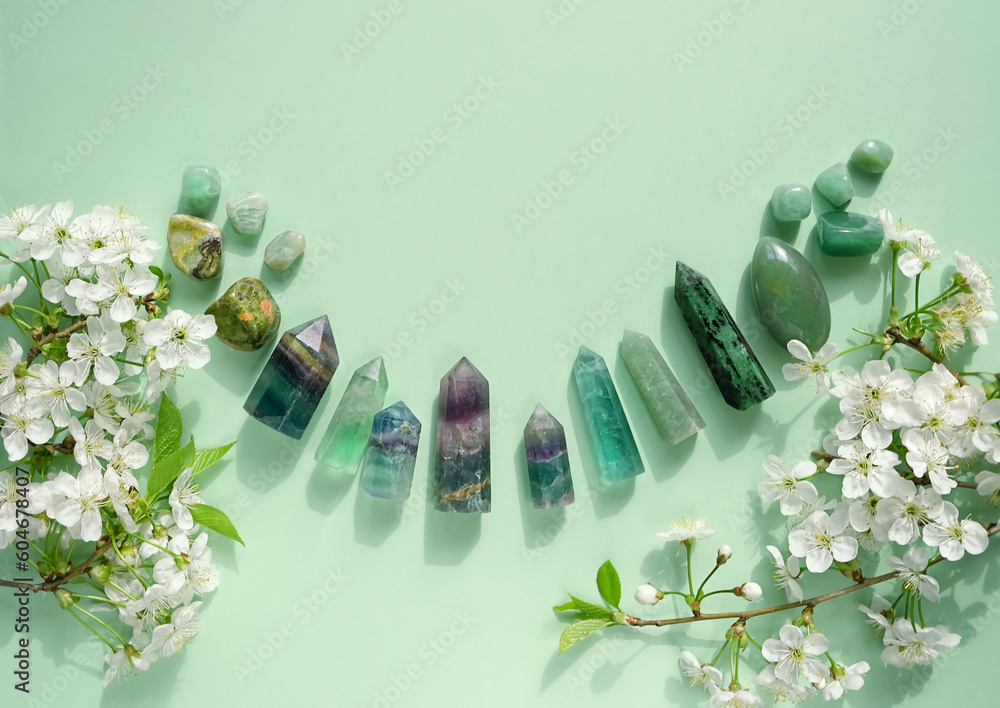 Crystal towers minerals set and white flowers on green abstract background. gemstones for Healing Crystal Ritual, Esoteric spiritual practice. wiccan magic, witchcraft. flat lay. copy space - obrazy, fototapety, plakaty 