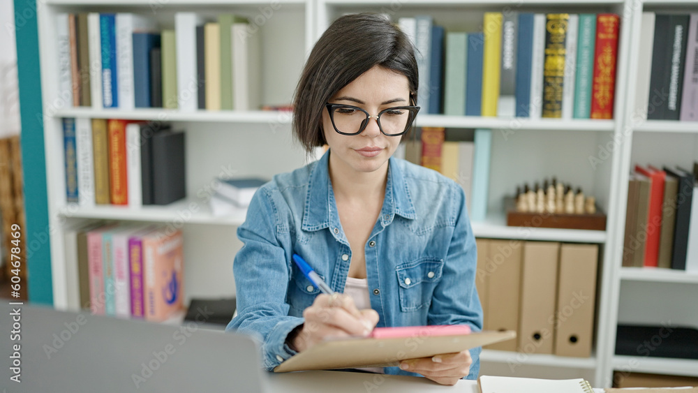 Young caucasian woman student writing on document at university classroom Young caucasian woman student writing on document at university classroom