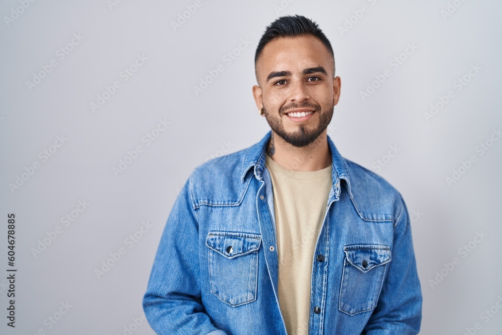 Young hispanic man standing over isolated background with hands together and crossed fingers smiling relaxed and cheerful. success and optimistic Young hispanic man standing over isolated background with hands together and crossed fingers smiling relaxed and cheerful. success and optimistic
