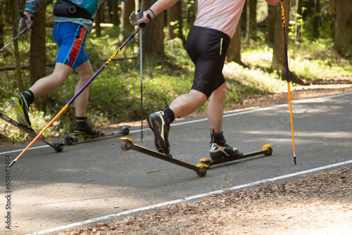 Fototapeta Naklejka Na Ścianę i Meble -  Roller skis.A man runs in a summer park on roller skis.Cross country skilling.