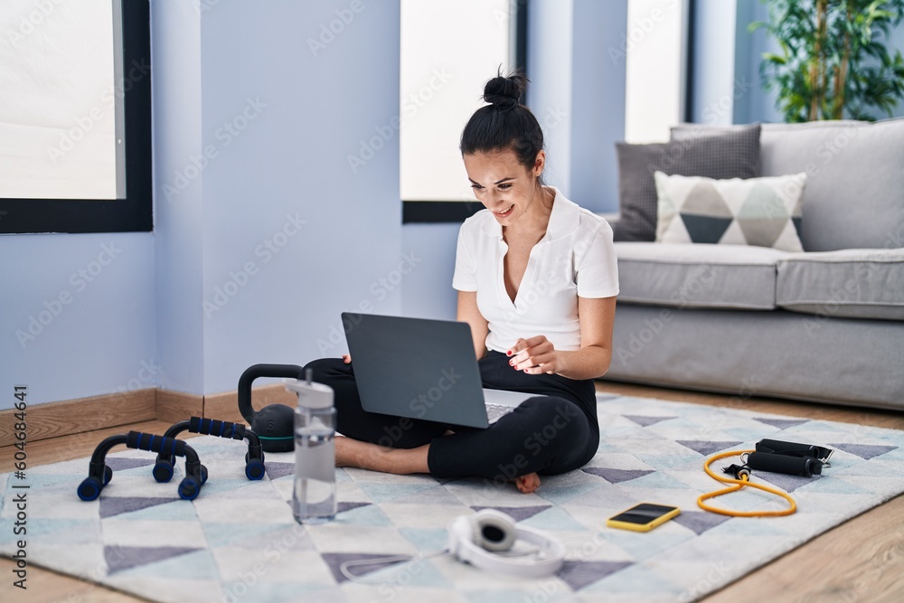 Young caucasian woman sporty using laptop sitting on floor at home Young caucasian woman sporty using laptop sitting on floor at home