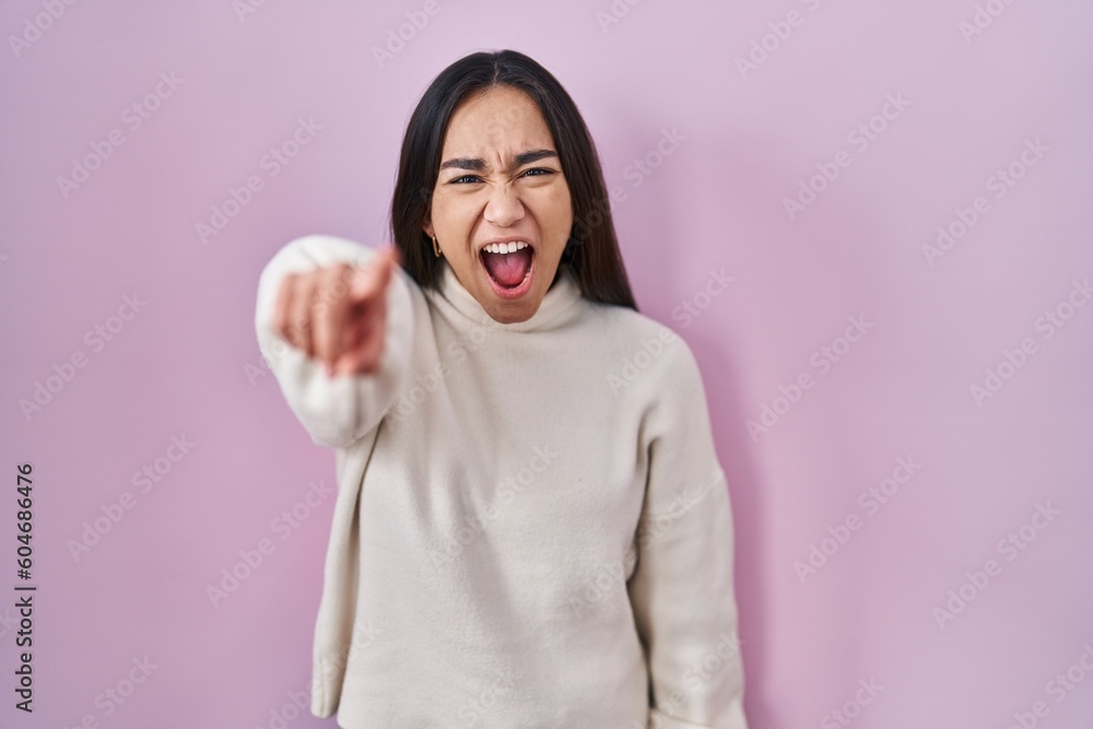 Young south asian woman standing over pink background pointing displeased and frustrated to the camera, angry and furious with you Young south asian woman standing over pink background pointing displeased and frustrated to the camera, angry and furious with you