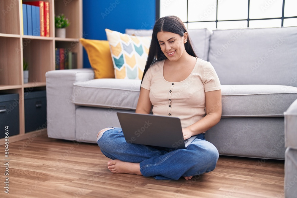 Young beautiful hispanic woman using laptop sitting on floor at home Young beautiful hispanic woman using laptop sitting on floor at home