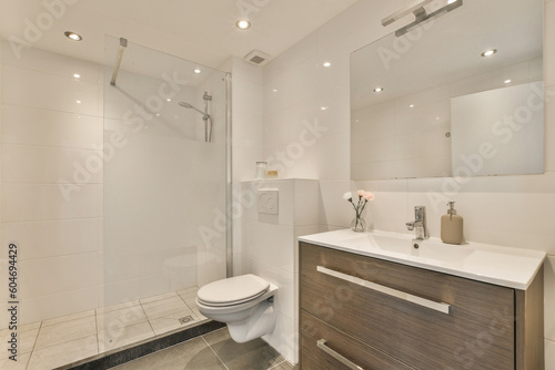 a bathroom with a toilet, sink and shower stall in the photo is taken from the front end of the room