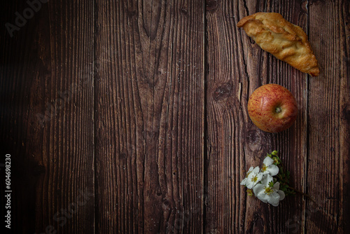 Little pastries with apples on dark wooden background 