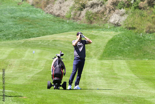 Man golfer with rangefinder on golf course photo